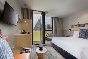 a hotel room with a bed and a tv at Brady Hotels Central Melbourne in Melbourne