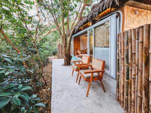a couple of chairs sitting on the porch of a house at Teresito Dragon Fruit Farm in Bantayan Island
