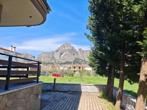 a bench with a view of a mountain at Under the rocks luxury in Kalabaka