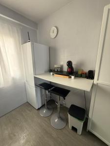 a small kitchen with a white counter and a refrigerator at Amplio piso para 8 a 2 min de Playa Santa Marina, 3 habitaciones in Ribadesella