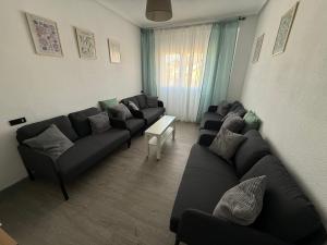 a living room with a couch and a table at Amplio piso para 8 a 2 min de Playa Santa Marina, 3 habitaciones in Ribadesella