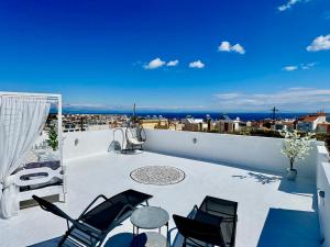 a balcony with chairs and a view of a city at Traditional Villa Sofia in Koskinou