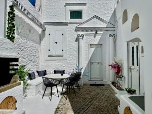 a white building with a table and chairs on a patio at Traditional Villa Sofia in Koskinou