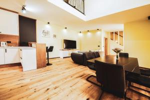 a living room with a dining table and a kitchen at Residence Legio XIII Gemina in Ptuj