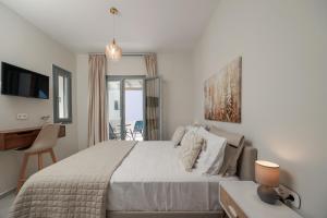 a bedroom with a large bed with a desk and a desk at Etherio Apartments Naxos in Galanádhon