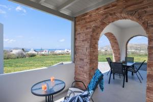a patio with an archway and a table and chairs at Etherio Apartments Naxos in Galanádhon