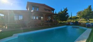 a house with a swimming pool in front of a house at The lodge corfu in Mesongi