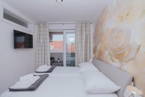 a bedroom with a bed and a painting on the wall at Relax Apartments in Novalja