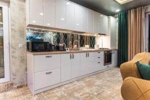a kitchen with white cabinets and a microwave at Complex Rediu 54 - Penthouse Nr. 41 in Iaşi