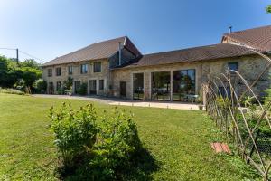 a large stone building with a lawn in front of it at Entre Loue et Lison in Amondans