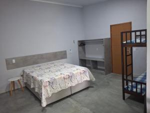 a bedroom with a bed and a shelf in it at Casa na praia prática aconchegante in Serra