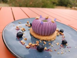 a dessert in the shape of a pumpkin on a blue plate at Une escale gourmande- Suite avec terrasse & dîner maison possible in Eyzerac
