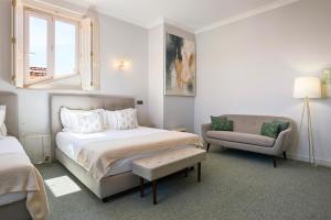 a white bedroom with a bed and a chair at Estoril Boutique Hotel - Adults Only in Estoril +72 photos