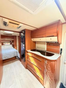 a kitchen with wooden cabinets and a bed in a room at Caravana Con encanto 5 in El Palmar