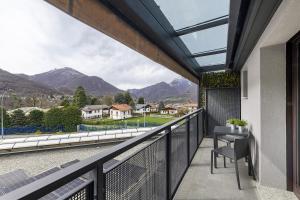 a balcony with a table and a view of mountains at Como's Lake Mountains beb in Cremeno