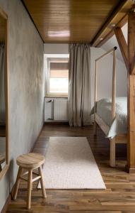 a bedroom with a bed and a stool and a window at De Bookholt - Premium Ferienwohnung in Vreden +27 photos