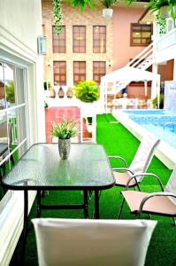 a patio with a table and chairs and a pool at Promesa White House in San Fernando