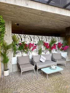 a patio with three chairs and a table and flowers at Casa Sciliar Stanza gold con parcheggio privato in Völs am Schlern