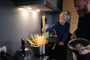 a young girl is preparing food in a kitchen at Wellnester Tiny Houses in Losheim am See in Losheim