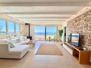 a living room with a white couch and a tv at Suite La Mer in Kalkan