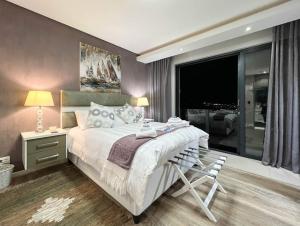 a bedroom with a large bed with a chair in it at Yadah Guest House in Mossel Bay +101 photos