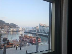 a window with a view of a river and a city at 아름다운호텔 in T'ongyŏng +5 photos