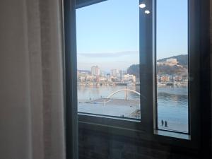 a window with a view of a river and a bridge at 아름다운호텔 in T'ongyŏng