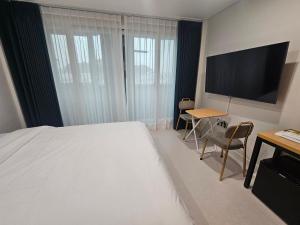 a bedroom with a bed and a desk and a television at 아름다운호텔 in T'ongyŏng