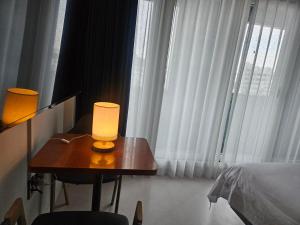 a lamp on a table in front of a window at 아름다운호텔 in T'ongyŏng