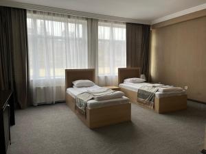 two beds in a hotel room with a window at Arena Hotel Tovuz in Tovuz