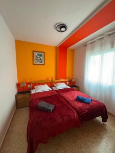 a bedroom with a large bed with red and yellow walls at Apartment Vicente casa 119 in Torrevieja