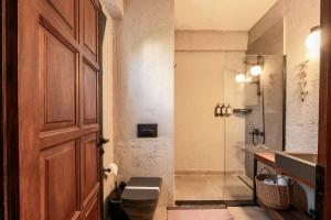a bathroom with a shower and a toilet and a door at GAIA ALAÇATI in Alaçatı +48 photos