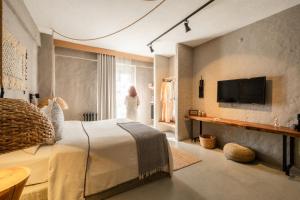 a bedroom with a bed and a tv on a wall at GAIA ALAÇATI in Alaçatı