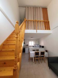 a staircase in a living room with a table and a kitchen at Maison à proximité de la plage in Prunete