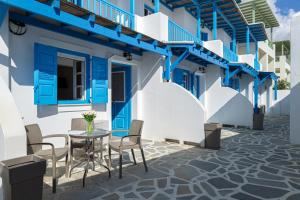 a patio with a table and chairs in front of a building at Anemos Sea View in Batsi