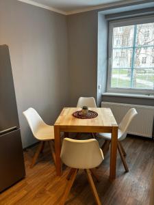 a dining room with a wooden table and white chairs at Apartmán u Hradu 2 in Cheb