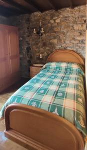a bedroom with a bed and a stone wall at Casa Rosario in Cortina +26 photos