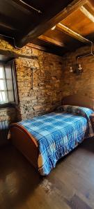 a bedroom with a bed in a brick wall at Casa Rosario in Cortina