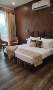 a bedroom with a large bed in a room at Orchards Suites Lansdowne in Lansdowne +7 photos