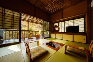 a living room with a table and some windows at Hozantei in Minamioguni