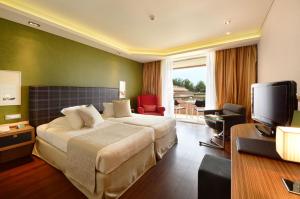 a hotel room with a bed and a television at Royal Paradise Beach Resort & Spa in Potos +38 photos