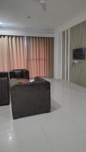 a living room with a couch and a television at Orchards Suites Lansdowne in Lansdowne
