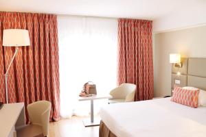 a hotel room with a bed and a window at Hotel Nice Riviera in Nice
