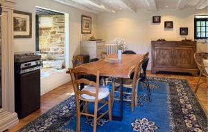 a kitchen and dining room with a wooden table and chairs at La Vieille Forge in Sarrazac