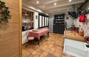 a kitchen with a table and chairs in a room at La Vieille Forge in Sarrazac