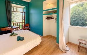 a bedroom with a bed and a blue wall at La Vieille Forge in Sarrazac