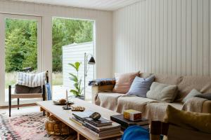 a living room with a couch and a coffee table at Thatched Hideaway At Svinkløv Forest Edge in Fjerritslev