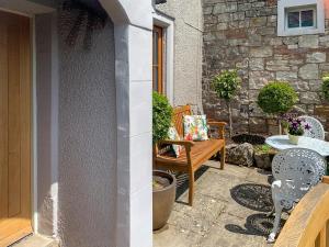 a patio with two chairs and a table and a table and chairs at The Mains in Keldhead