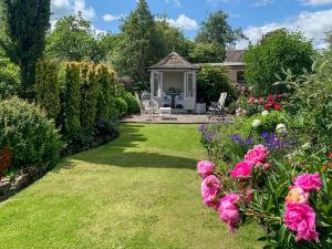 a garden with a gazebo and pink flowers at The Mains in Keldhead