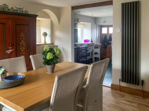 a kitchen and dining room with a wooden table and chairs at The Mains in Keldhead +5 photos